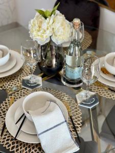 uma mesa com pratos e copos e um vaso com flores em M Luxury Home In Irene Centurion-No Blackouts em Centurion