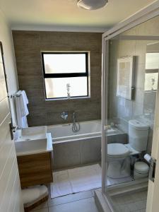a bathroom with a tub and a toilet and a sink at M Luxury Home In Irene Centurion-No Blackouts in Centurion