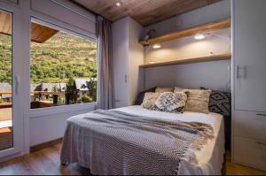 a bedroom with a bed and a large window at Apartaran 407 con terraza in Betrén