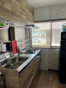 a kitchen with a sink and a stove at サンライズ日南 in Nichinan