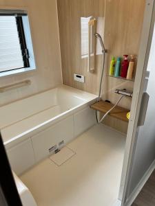 a bathroom with a bath tub and a sink at サンライズ日南 in Nichinan +7 photos