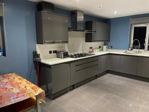 a kitchen with gray cabinets and a blue wall at Sweet street in Barton in the Clay