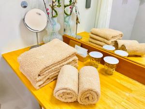 a wooden table with towels and glasses on it at Hotel Little Swiss House in Motobu +70 photos