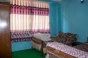 a room with two beds and a window with curtains at Kirtipur Community Homestay in Kirtipur