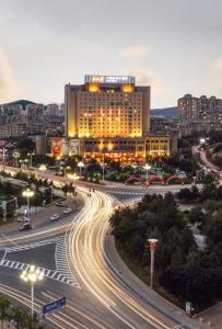 una ciudad con un edificio y una calle con coches en S&N Hotel Dalian, en Wafangdian