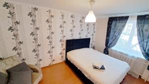 a small bedroom with a bed and a chair at Teatra 32 in Daugavpils