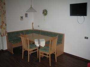a dining room table with chairs and a couch at Schlernheim Apartment in Völs am Schlern