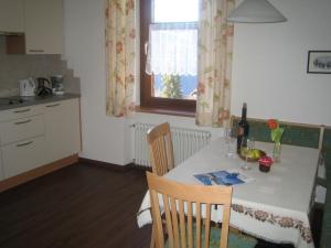 a kitchen with a table and a window and a table and chairs at Schlernheim Apartment in Völs am Schlern