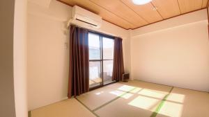 an empty room with a large window and sunlight at Esperanza 204号室 in Tokyo