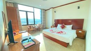 a bedroom with a bed and a desk and a television at HỒNG PHƯƠNG HOTEL in Cao Bằng