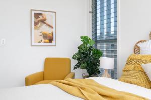 1 dormitorio con 1 cama, 1 silla y 1 planta en Oceanviews on Pearl, en Kingscliff 20 fotos más
