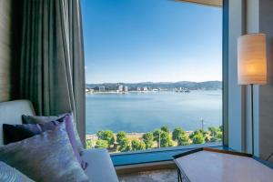 a room with a large window with a view of the water at Hotel Ichibata in Matsue