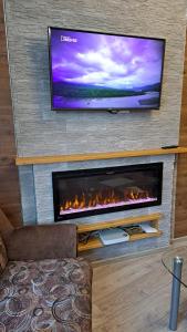 a living room with a fireplace with a flat screen tv at Rigas 72 in Daugavpils