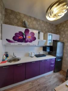 陶格夫匹爾斯的住宿－Rigas 72，厨房配有紫色橱柜、水槽和冰箱