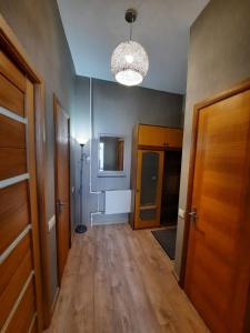 a hallway with wooden floors and a light fixture at Rigas 72 in Daugavpils