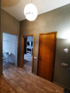 Habitación con pasillo con puerta y lámpara de araña. en Rigas 72, en Daugavpils