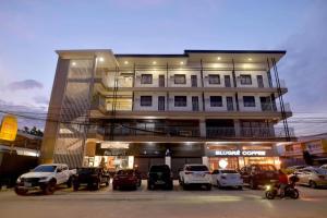 un edificio con coches estacionados frente a él en FLOROTEL II, en General Santos