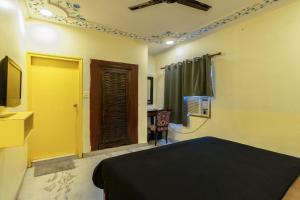 a bedroom with a bed and a tv and a window at The Hosteller Jaipur in Jaipur