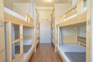 a room with four bunk beds in a hostel at Manas B&B in Taitung City