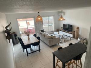 uma sala de estar com um sofá e uma mesa em Appartement T3 climatisé,balcon em Le Boulou