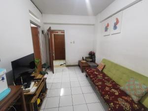 sala de estar con sofá y TV en Cibubur Village Wina Property, en Cibubur