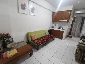 sala de estar con sofá verde y cocina en Cibubur Village Wina Property, en Cibubur