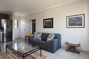 a living room with a blue couch and a glass table at Bay Lodge 29 in Ballito