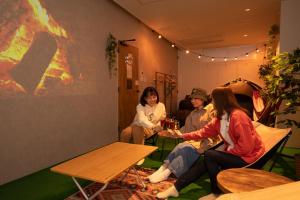 a group of people sitting at tables in a room at Glamping Tokyo Asakusa in Tokyo