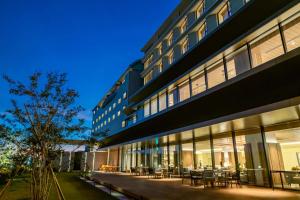 a building with tables and chairs in front of it at Hotel Ichibata in Matsue