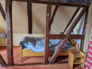uma cama num quarto com vigas de madeira em Altmark - Haus am Hang mit Garten 