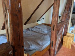 uma cama num caixilho de madeira num quarto em Altmark - Haus am Hang mit Garten 