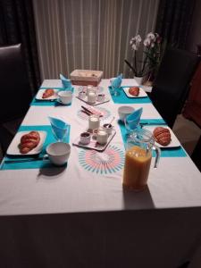 une table avec des plaques alimentaires et un verre de jus d'orange dans l'établissement Chez Bernard et Nicole, à Betton