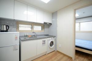 a kitchen with a sink and a washing machine at Sunnyhill Guesthouse Hongdae in Seoul