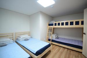 1 Schlafzimmer mit 2 Etagenbetten und einer Decke in der Unterkunft Sunnyhill Guesthouse Hongdae in Seoul