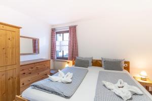 1 dormitorio con 2 camas individuales y TV en Almlove, en Bad Hindelang