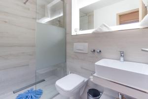 een badkamer met een toilet, een wastafel en een spiegel bij Almlove in Bad Hindelang