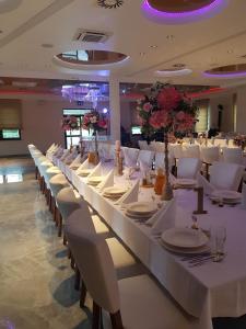 Villa Con Amore في Słońsk: غرفة طعام طويلة مع طاولات بيضاء وكراسي بيضاء