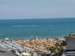 uma praia com um monte de guarda-sóis e o oceano em B&B Primrose Residence Hotel em Rimini