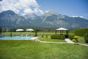 a garden with a pool and a view of mountains at Hotel Cafe-Zillertal in Strass im Zillertal