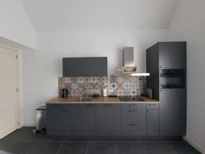 a kitchen with a wooden counter top and a black refrigerator at De Bloemenkwekerij in Egmond-Binnen