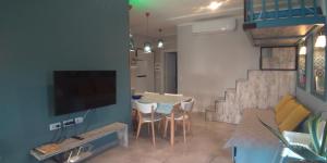 a living room with a table and a dining room at Welcome Beach Apartment in Hamallë