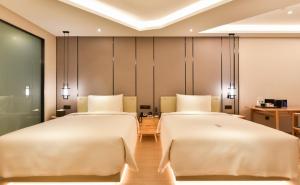 - deux lits dans une chambre d'hôtel avec deux couvre-lits dans l'établissement Atour Hotel Beijing Fuxingmen, à Pékin