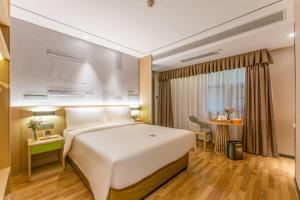 a hotel room with a large white bed and a window at Atour X Hotel Xiamen Zhongshan Road Ferry Wharf in Xiamen