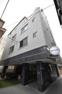 un edificio con un cartel en la parte delantera en Sunnyhill Guesthouse Hongdae, en Seúl