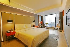 Atour S Hotel Chengdu Taikoo Li في تشنغدو: غرفة الفندق بسرير كبير ومكتب