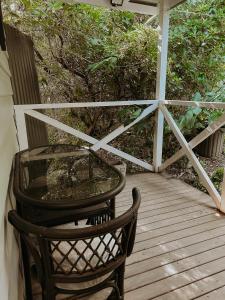 a table and a chair on a wooden deck at Misty Mountain Retreat in Olinda