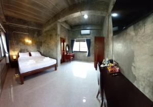 a bedroom with a bed and a table in a room at Khwaithai Resort & Homestay - ควายไทย 