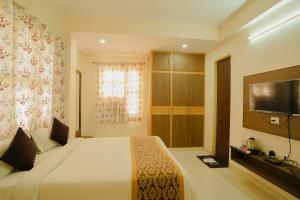 a bedroom with a large bed and a television at Hotel Cheelgadi in Jaipur