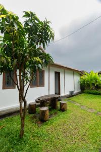 een huis met een picknicktafel en een boom bij Singgah di Ubud 1 in Ubud