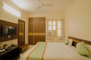 a bedroom with a large bed and a flat screen tv at Hotel Cheelgadi in Jaipur